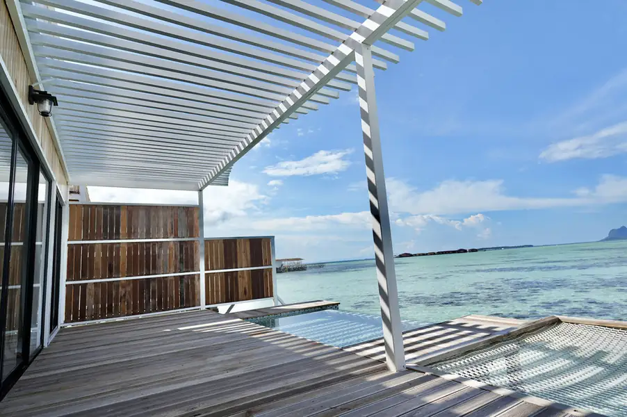 Private oceanview balcony with a circular overwater mesh bed at F-Lina Water Villa Resort. A meditative haven perched above the Celebes Sea offering absolute barefoot luxury.