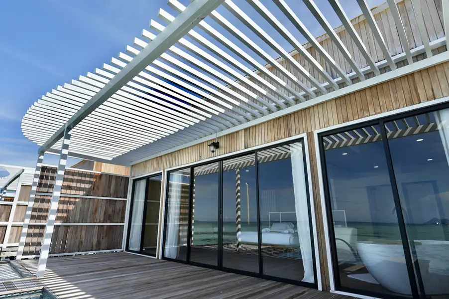 Modern private sun-drenched balcony with a white pergola roof at F-Lina Water Villa Resort, an intimate over the water escape in Semporna offering a barefoot luxury retreat.